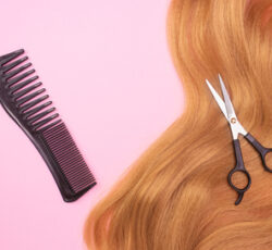 Red,artificial,hair,on,a,pink,background,,comb,and,scissors.